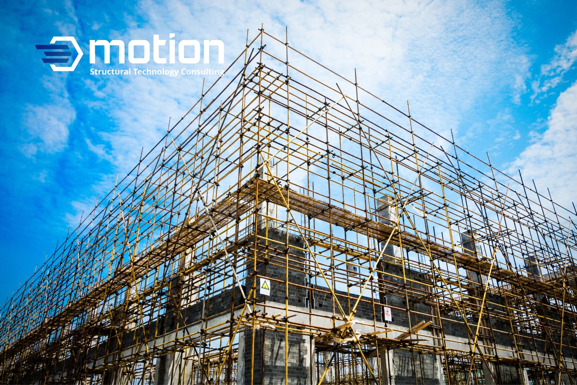 Scaffolding surrounds a partially constructed building, featuring the STC Motion logo, illustrating their construction process.